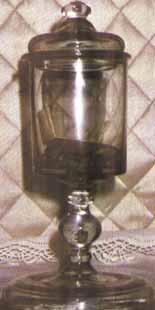 A glass container holding a relic, set against a patterned background.