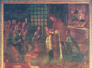 A group of people in a church setting, with a priest giving communion to a kneeling woman.
