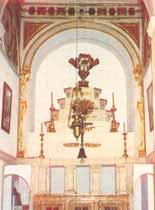 An ornate altar with religious artifacts and decorations, featuring a central candelabrum.