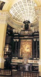 The image shows the ornate interior of a church with a detailed ceiling and altar.