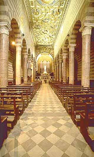 The image shows the interior of a cathedral with ornate ceilings and rows of wooden pews.
