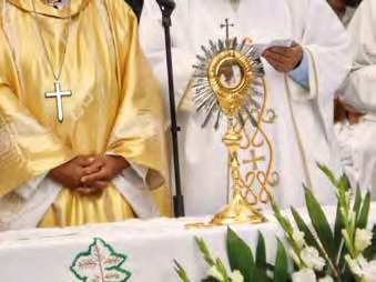 Two priests in liturgical vestments with a monstrance during a religious ceremony.