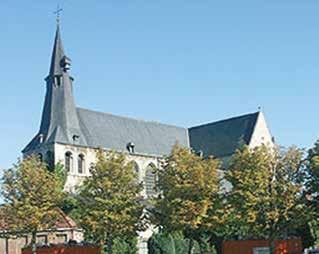 A photograph of the Church of St. James in Louvain, showcasing its architecture and surrounding trees.