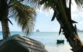 A tropical beach scene with palm trees, a boat, and a distant island.
