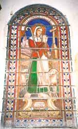 Stained glass depiction of Saint Germaine Cousin with a shepherd's staff and a sheep.