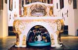 An ornate altar with intricate gold detailing inside a church setting.