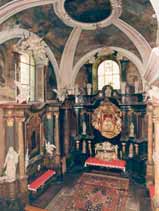 An ornate church interior with a decorated altar and arched ceiling.