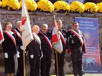 A group of people in formal attire holding flags at a ceremony.