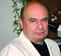A portrait of a man in a white coat, looking directly at the camera.