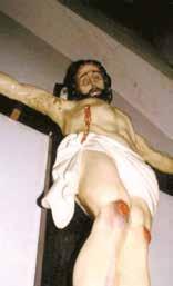 A close-up of a crucifix showing Jesus with visible wounds and a crown of thorns.