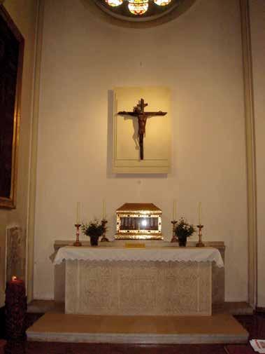 Altar with a crucifix that extended its arms during the Regensburg miracle, flanked by candles and flowers.
