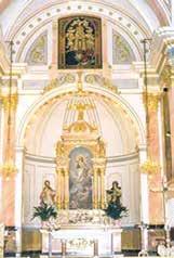 Interior view of a church with ornate decorations and a central altar.