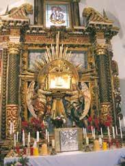 An ornate altar with a relic displayed, surrounded by candles and decorations.