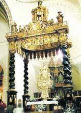 A richly decorated altar featuring ornate columns and a central religious figure.