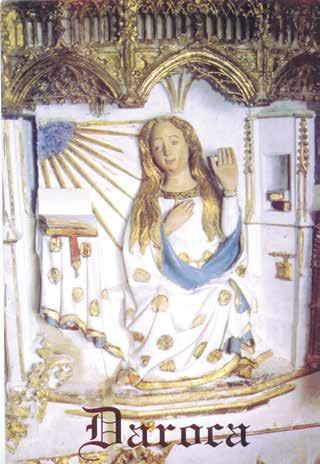 A statue of a seated figure with a blue robe and golden accents, holding a hand up in blessing.