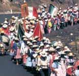 A procession of people carrying banners and flags, likely in a religious context.