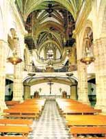 Interior view of a church with wooden benches and ornate architecture.