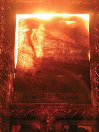 An image of a relic stained with blood, framed and illuminated.