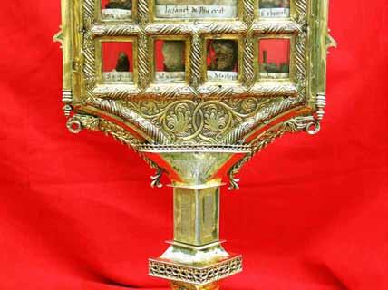 A golden reliquary with multiple compartments displaying religious artifacts.