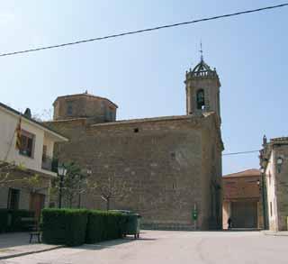 Exterior view of the Church of San Cugat with its bell tower and surrounding buildings.