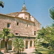 A stone church with palm trees in front, showcasing its architectural features.