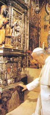 An image of a religious figure with ornate decorations, showing a man in white reverently approaching.