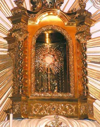An ornate shrine displaying the miraculous Host, surrounded by rays of light and intricate decorations.