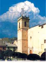 Church of St. James the Apostle in Onil, where the miraculous Host is housed, under a vibrant blue sky.