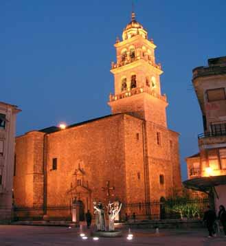 A beautifully illuminated church building at dusk, showcasing its architectural features.
