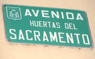 A street sign reading 'Avenida Huertas del Sacramento'.