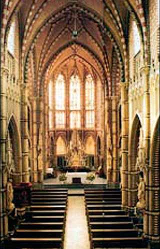 A view of the interior of Saint Trudo's Church featuring its architectural details and pews.
