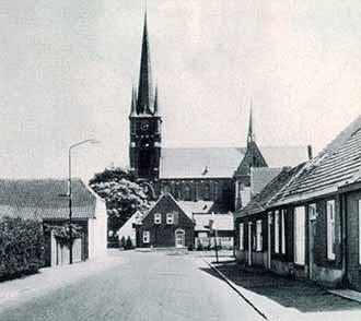 A historical image of Saint Trudo's Church, showcasing its distinctive towers and surrounding buildings.